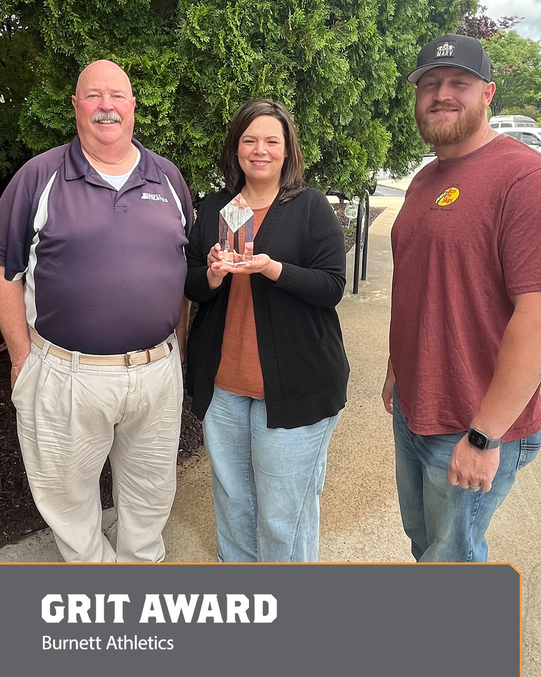 Image of two men and a woman holding an Ace Award.